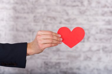 adamların ellerinde kırmızı kalp