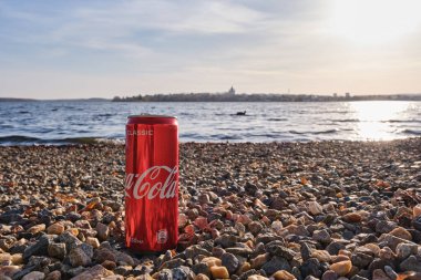 Kaya plajında bir kutu kola duruyor.