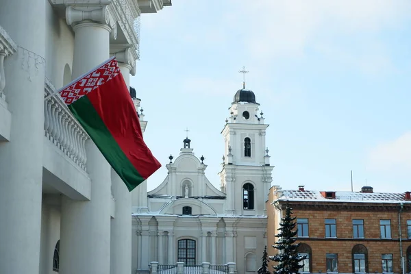 Fragmento de um edifício antigo com colunas com uma bandeira de estado de Belarusian acenando. Igreja Católica. — Fotografia de Stock