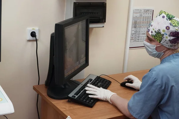 Uma radiologista mulher atrás do monitor faz uma correção de raio-X. — Fotografia de Stock