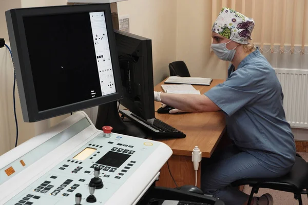 Μια γυναίκα ακτινολόγος πίσω από την οθόνη κάνει μια διόρθωση ακτίνων Χ. — Φωτογραφία Αρχείου