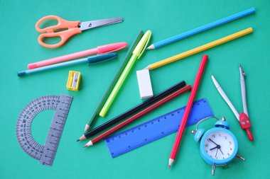 Yeşil arka planda kırtasiye malzemeleri. 1 Eylül bilgi günüdür..