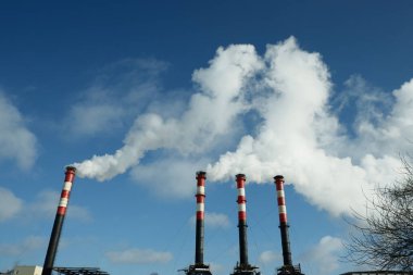 Fabrika bacalarından çıkan duman atmosferi kirletiyor. Çevre kavramı.