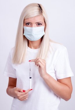 Kadın doktor veya hemşire tıbbi maskesi holding şırınga ile inje