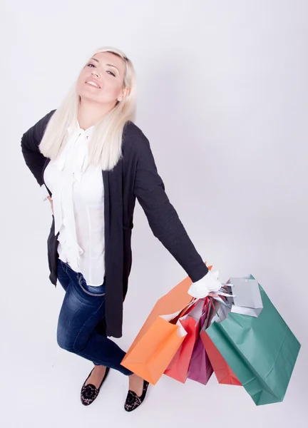 Retrato de uma mulher loira com sacos de compras em um estúdio — Fotografia de Stock