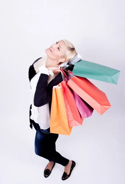 Bir stüdyoda alışveriş torbaları ile sarışın bir kadın portresi — Stok fotoğraf