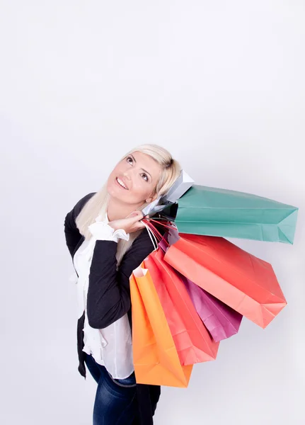 Portrait of a blond woman with shopping bags in a studio — Stock Photo, Image