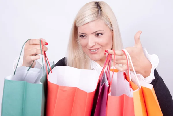 Portrait d'une femme blonde avec des sacs à provisions dans un studio — Photo