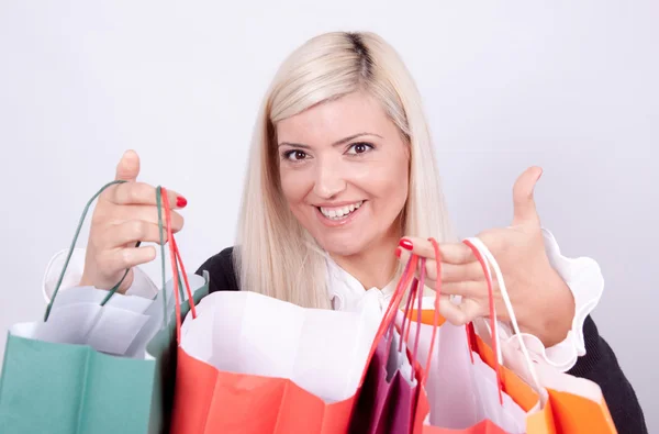 Portrait of a blond woman with shopping bags in a studio — Stock Photo, Image