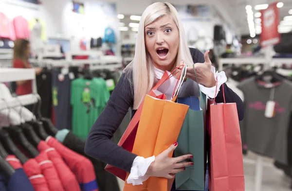 Sonriente joven rubia en tienda de ropa — Foto de Stock