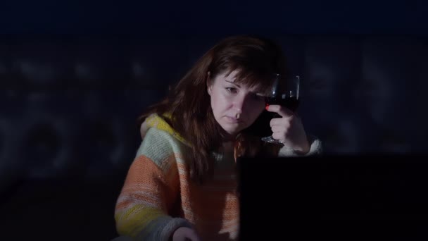 szomorú nő egy pohár bor mellett a tv-ben este otthon, gondolkodás, depresszió