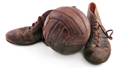 Shoes for soccer and an old leather soccer ball