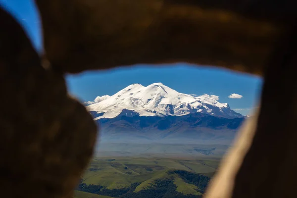 Platodan sönmüş volkana ve Elbrus Dağı 'nın karlı zirvesine taş çerçevenin içinden mükemmel bir manzara.