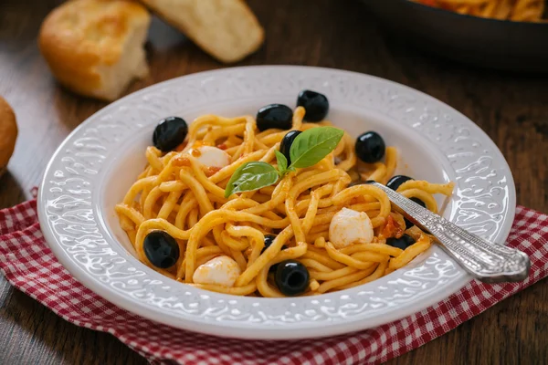 Spaghetti z sosem pomidorowym, oliwki i mozzarellą — Zdjęcie stockowe