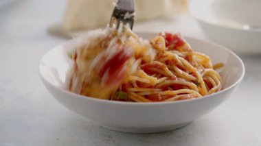 Domates soslu spagetti ve bir tabak fesleğen.