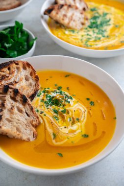 Kabak çorbası kızarmış ekmek, maydanoz ve zeytinyağı ile servis edilir..