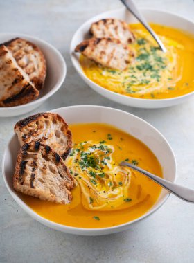 Kabak çorbası kızarmış ekmek, maydanoz ve zeytinyağı ile servis edilir..