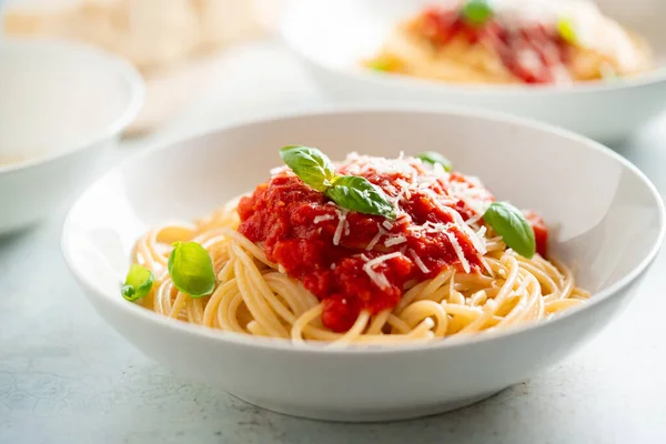 Espaguetis con salsa de tomate y albahaca en un plato —  Fotos de Stock