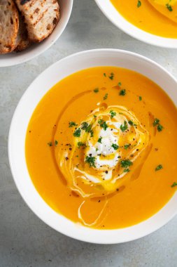 Kabak çorbası kızarmış ekmek, maydanoz ve zeytinyağı ile servis edilir..