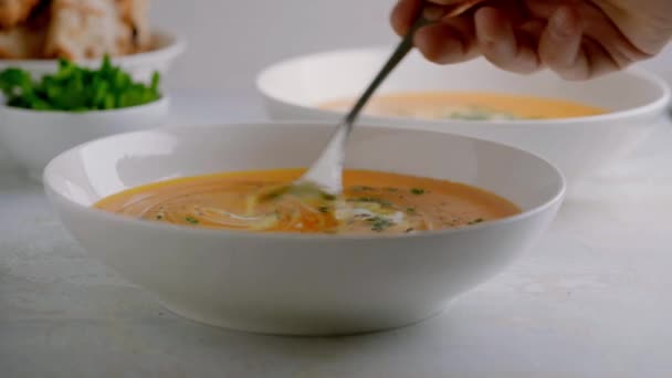 Sopa de abóbora servida em uma tigela com croutons, salsa e azeite. — Vídeo de Stock