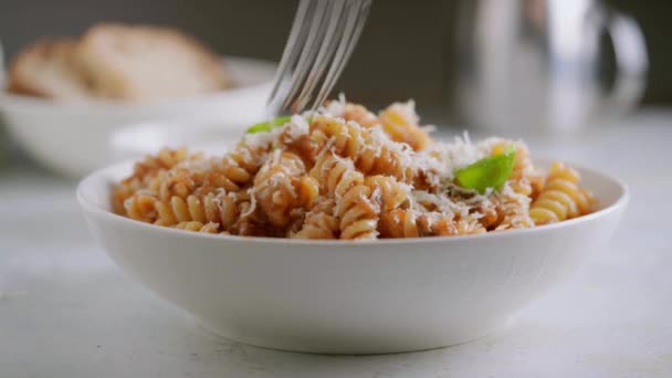 Syökää fusilli-pastaa tomaattikastikkeen, paahdetun munakoison ja parmesaanijuuston kanssa. — kuvapankkivideo
