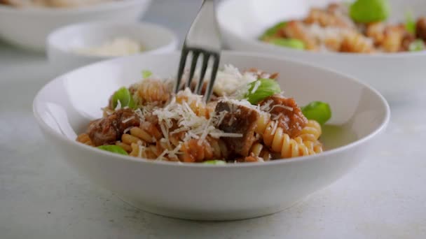Syökää fusilli-pastaa tomaattikastikkeen, paahdetun munakoison ja parmesaanijuuston kanssa. — kuvapankkivideo