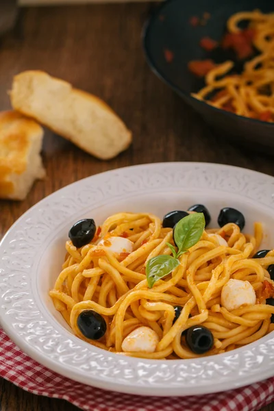 Спагетті з томатним соусом, оливками та моцарелою — стокове фото