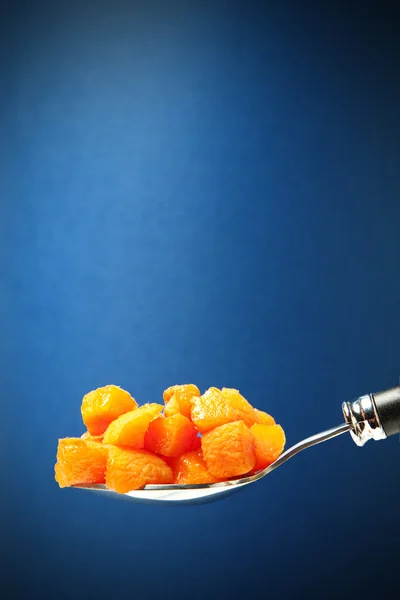 Spoon with apricot pieces — Stock Photo, Image