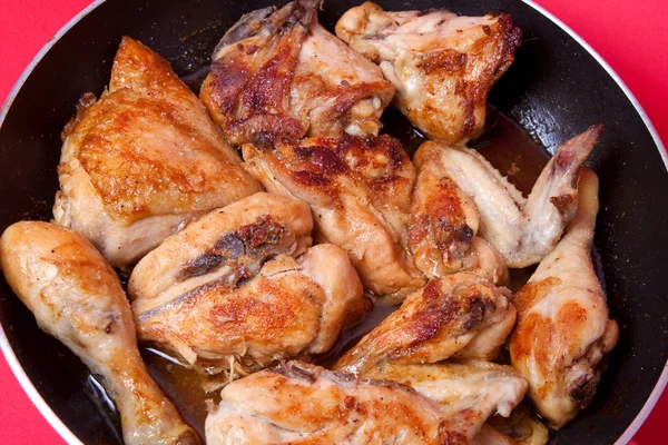 Roast chicken in the pan on a red background — Stock Photo, Image