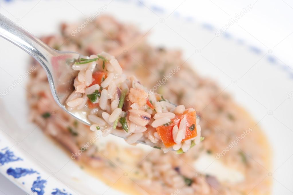 Seafood risotto with fork and plate background