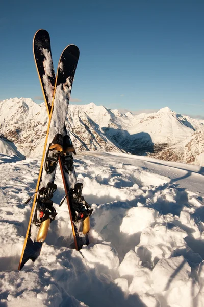 Skis dans la neige dans les montagnes — Photo