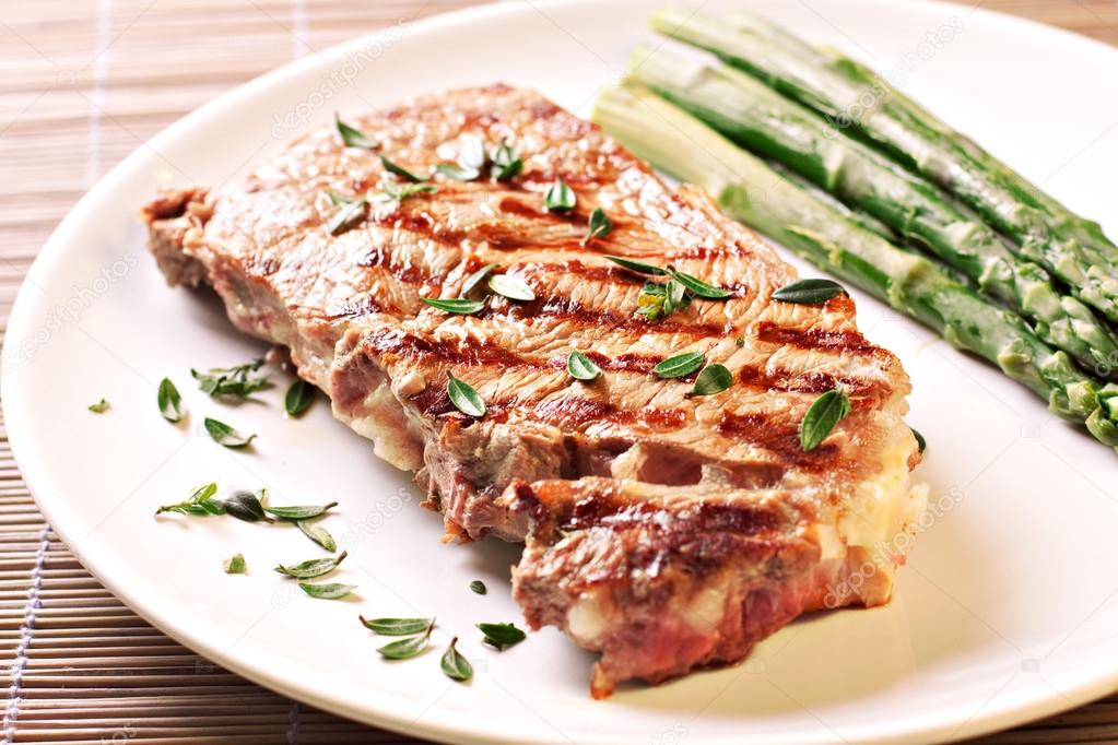 Steak with asparagus on plate