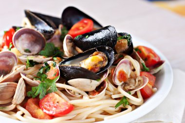 Deniz mahsulleri spagetti beyaz plaka üzerinde