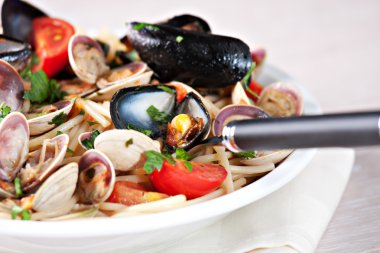 Deniz mahsulleri spagetti beyaz plaka üzerinde