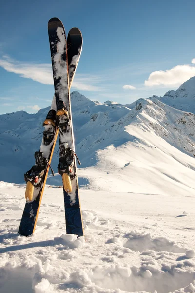 Skis dans la neige dans les montagnes — Photo