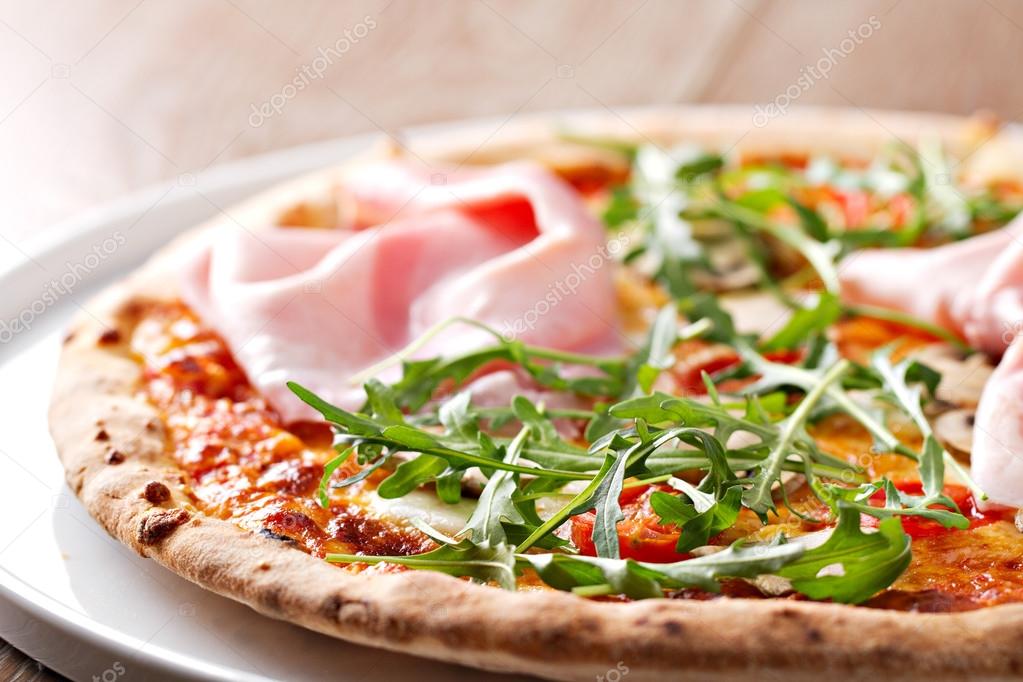 Pizza with ham and roket salad
