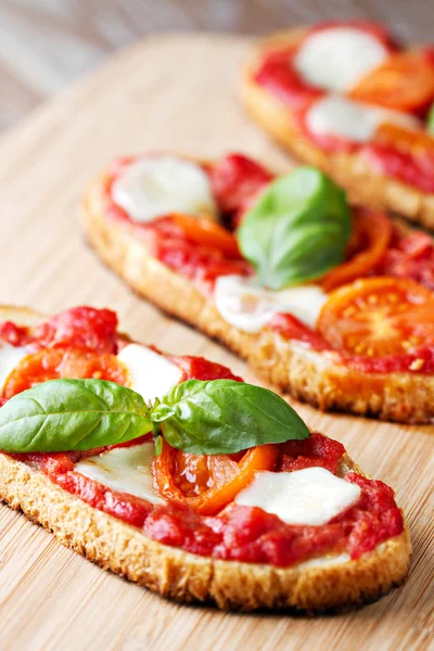 Bruschetta com tomate, mussarela e manjericão — Fotografia de Stock