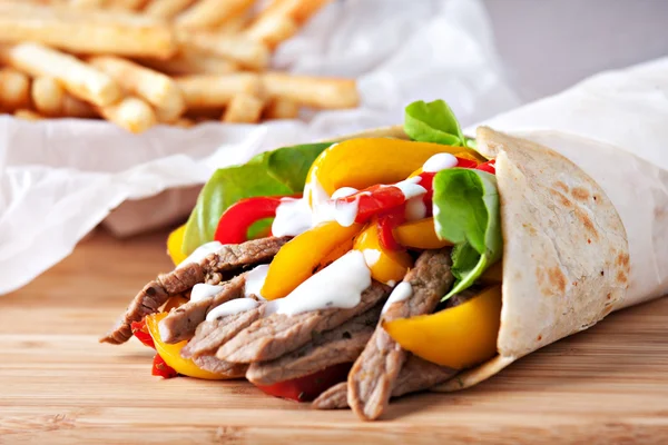 Fajitas con papas fritas sobre mesa de madera —  Fotos de Stock