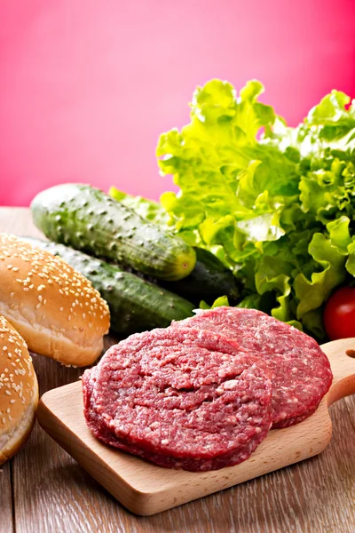 Ingredientes para hambúrgueres na mesa de madeira — Fotografia de Stock