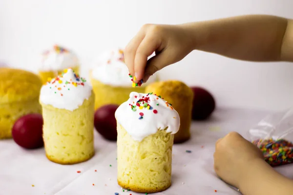 Bebek pastayı renkli bir serpintiyle süslüyor