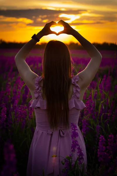 Gün batımında pembe elbiseli kız