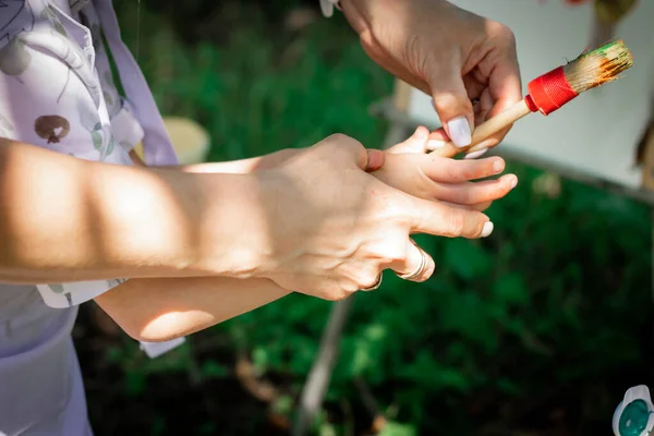 Anne çocuğun çizmesine yardım ediyor..
