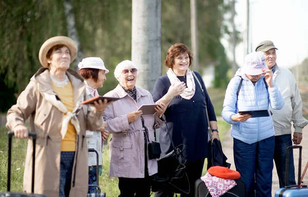 Grupa Pozytywnych Starszych Osób Podróżujących Pomocą Tabletów Czekających Pociąg Przed — Zdjęcie stockowe