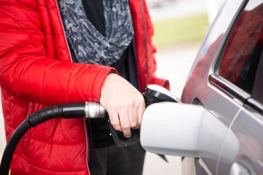 Yakıt istasyonunda yakıt ikmali yapan bir adam var. Yolculuğa hazırlanın.