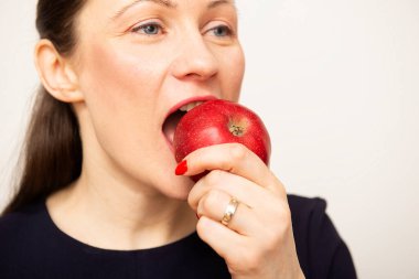 Elma yiyen genç ve güzel bir kadının yakın çekimi. Beyaz izole arkaplan