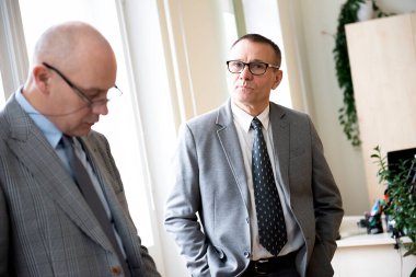 Ofiste konuşan ve çalışan iki ciddi orta yaşlı iş adamının portresi.