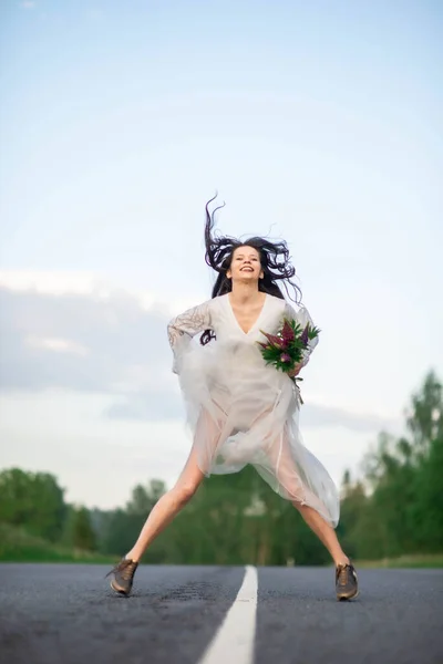 Funny Young Woman White Dress Jumping Empty Asphalt Road — Stockfoto