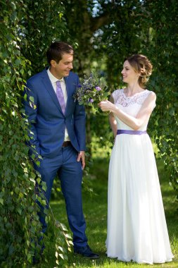 Düğün günlerinde genç gelin ve damat mutlu olsun. Düğün çifti - yeni aile! Gelinlik. Çiçeklerin düğün buketi