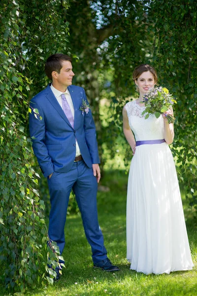 Düğün günlerinde genç gelin ve damat mutlu olsun. Düğün çifti - yeni aile! Gelinlik. Çiçeklerin düğün buketi