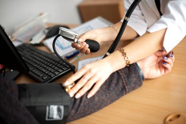 Kadın doktor, hastanedeki hastanın kan basıncını ölçüyor.